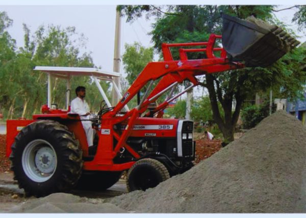 A Murshid Farm Industries Implement HYDRAULIC FRONT END LOADER attached to a tractor, loading mud.