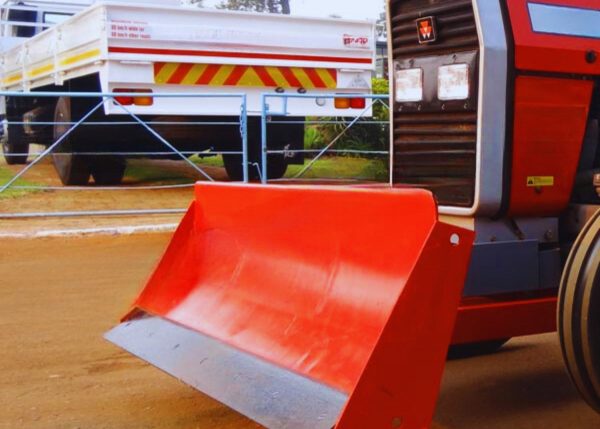 A hydraulic front blade attached to a tractor, seen from the left side.