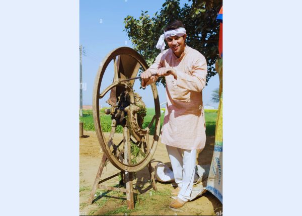 A farmer holding a Murshid Farm Industries Implement fodder chopper.