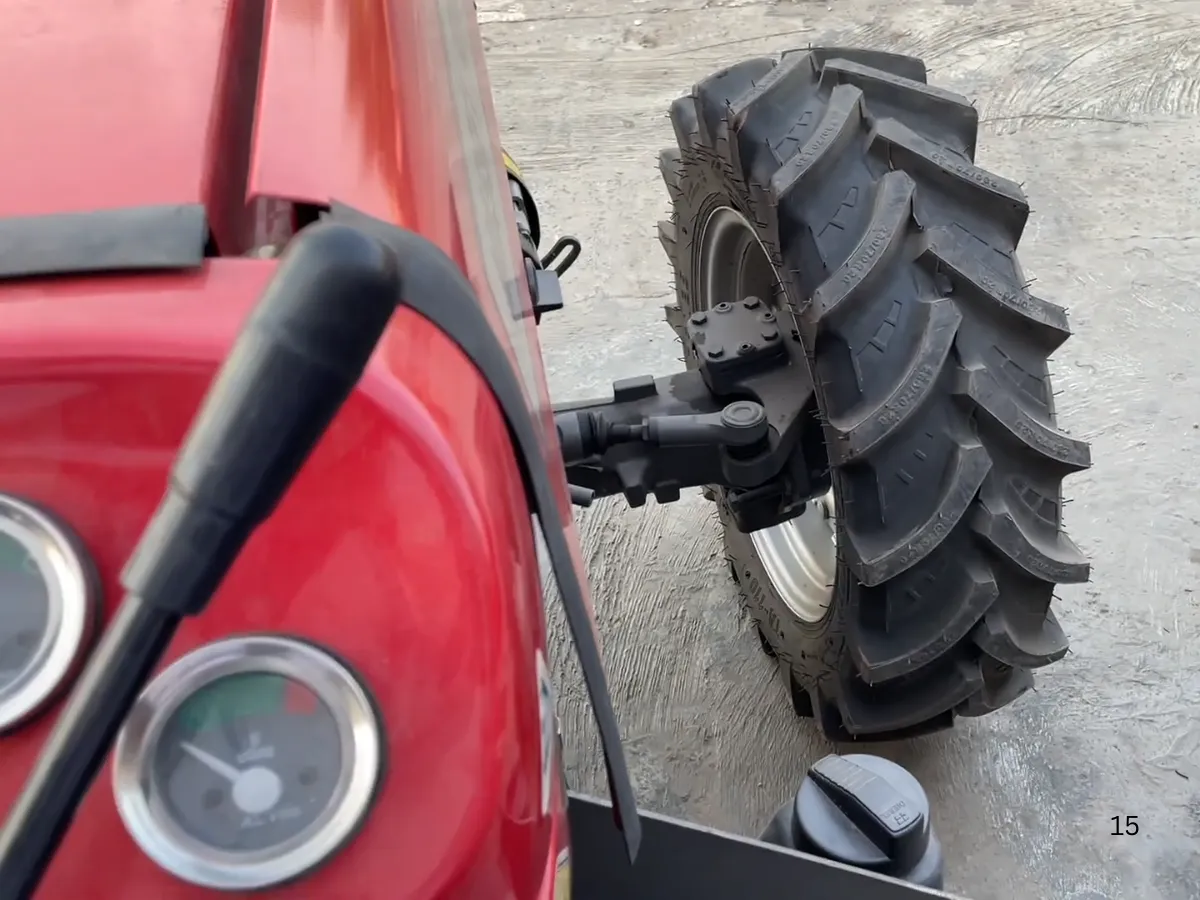 Massey Ferguson MF 360 Turbo 4WD 60HP tractor manufactured by Millat Tractors Pakistan, showing front wheel, steering linkage, and instrument panel edge