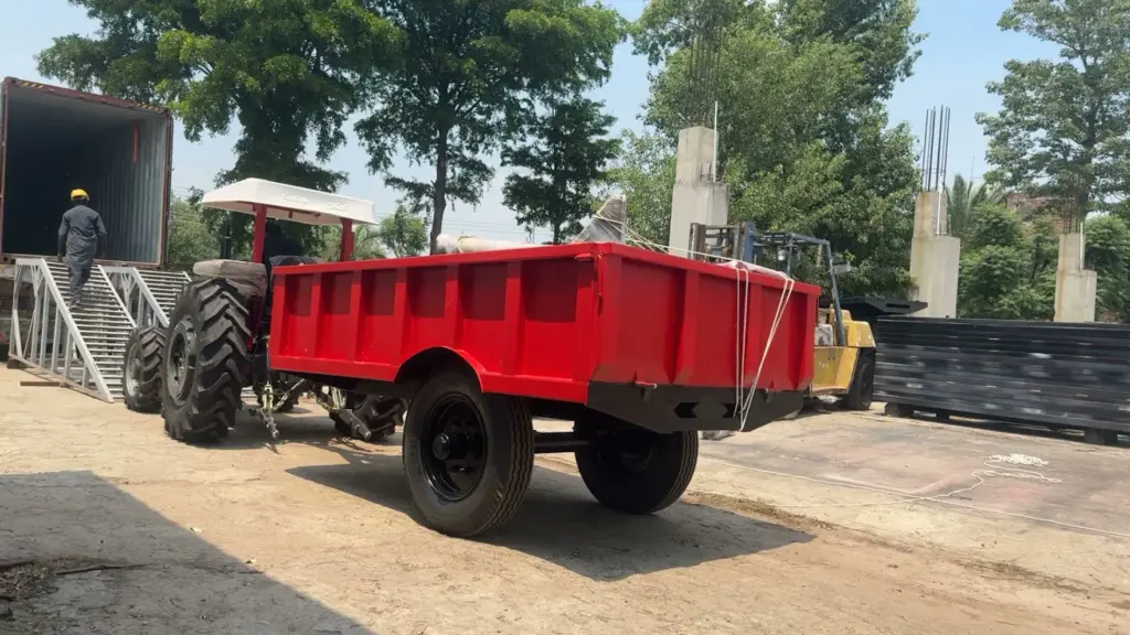 Agricultural trailer near loading ramps Red agricultural trailer parked beside loading ramps in a yard